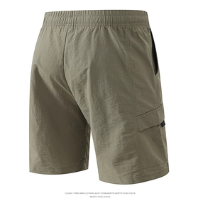 Detail view of olive green nylon cargo shorts with elastic waist and side flap pocket