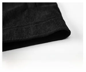 Close-up of black corduroy jacket hem showing ribbed texture and tight stitching detail
