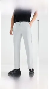 Detail of light gray pants showing elastic waistband and adjustable drawstring cord