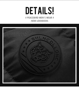 Close-up of windproof fabric texture and premium black rubber tiger badge on men's winter coat
