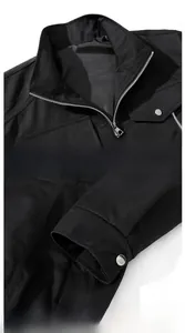 Detail of men black utility jacket showing stand collar and snap button cuffs