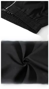Detailed macro view of black bomber jacket featuring elastic hem and durable zipper hardware