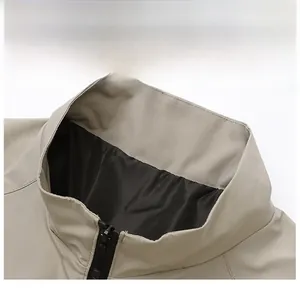 Close-up of a khaki baseball jacket with a crisp stand collar and black lining