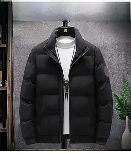 Detail view of black padded jacket featuring stand-up collar and circular sleeve badge