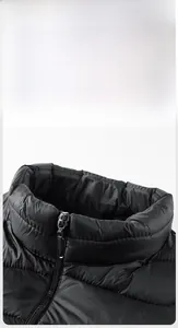 Detail view of the stand-up collar and SPORT metal zipper on black padded winter jacket