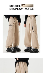 Detail of adjustable drawstring hem and cargo pockets on beige technical trousers