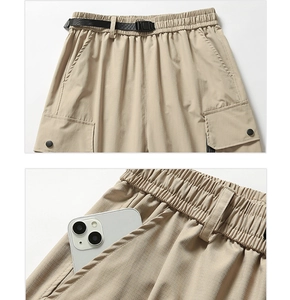Detail of khaki cargo pants featuring adjustable elastic waistband and ripstop fabric texture