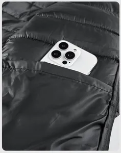 Detail shot of the inner safety pocket in a black puffer jacket with a smartphone inside