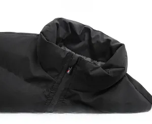 Close-up of black puffer jacket stand collar featuring zipper with tri-color detail