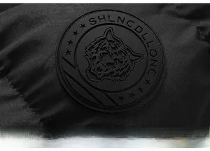 Detail of a high-quality black jacket featuring a 3D tiger embossed rubber badge