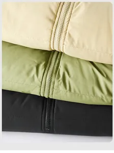 Detail view of smooth zipper closure and horizontal stitching on colorful winter puffer coats