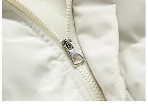 Detailed close-up of smooth silver metal zipper on cream white padded winter jacket