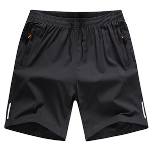 Detail of men's black quick-dry shorts featuring an orange zipper pocket and drawstring waist