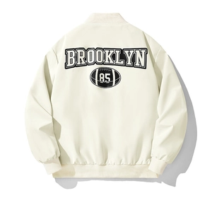 Detail der Rückseite mit Brooklyn 85 Aufdruck auf dieser cremeweißen Baseball-Jacke