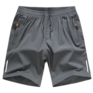 Macro shot of dark gray athletic shorts featuring zip pockets and orange accents
