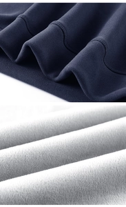 Close-up detail of thermal jacket with dark blue knitted surface and soft grey fleece lining