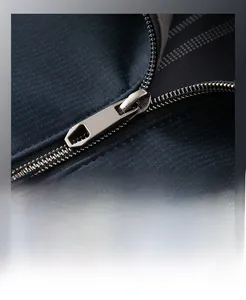 Macro detail of smooth silver metal zipper on navy blue textured casual jacket