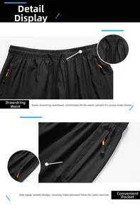 Detail of black quick-dry sports shorts with elastic drawstring waist and orange zipper pocket