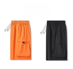 Detail view of loose fit cargo shorts in black and orange with elastic drawstring waist