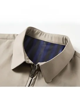 Detailed view of khaki men's jacket collar with blue striped lining and metal zipper