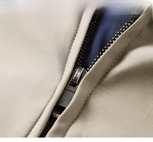 Detail of high-quality metal zipper on a khaki twill jacket with contrast blue lining