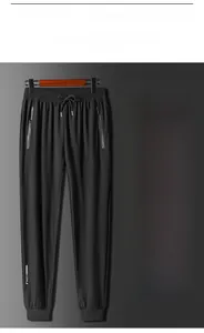 Vue détaillée de la taille élastique avec cordon et poche zippée d'un pantalon en soie glacée