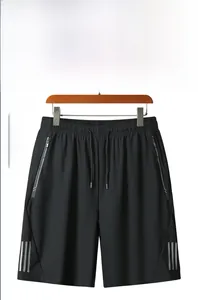 Detail of black quick-dry shorts with drawstring waist and reflective side stripes