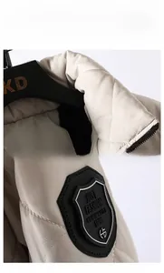 Detail of stand collar quilting and leather sleeve patch on men beige padded winter jacket