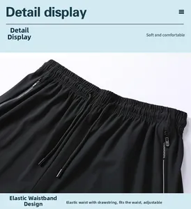 Detail view of elastic waistband with adjustable drawstring and zipper pockets on black shorts