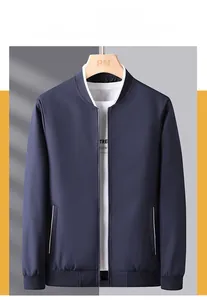 Detail of dark blue baseball collar jacket featuring ribbed cuffs and white trim pockets