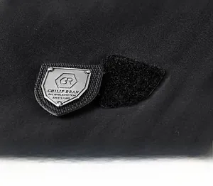 Détail d'un écusson métallique avec velcro sur une veste en polaire noire