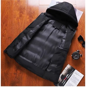 Vue détaillée d'un gilet noir à capuche avec étiquette taille M sur un fond en bois