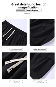 Detail view of elastic waistband, flat drawstring and side pockets of black cargo shorts