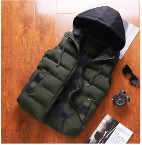 Gilet rembourré vert foncé à capuche avec fermeture éclair et doublure noire sur bois