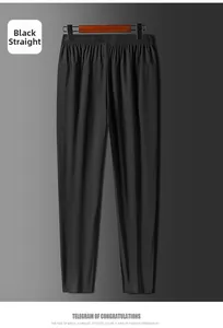 Détail du pantalon noir en soie glacée avec taille élastique et coupe droite