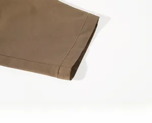 Detailed macro view of khaki trouser hem with precise stitching and twill fabric texture