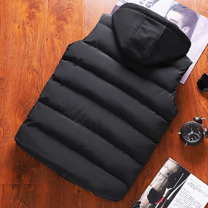 Gilet rembourré noir à capuche pour homme avec design matelassé sur fond bois