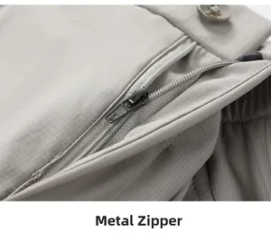 Detail of light gray business trousers featuring a metal zipper and micro-grid texture