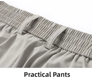 Detail of light gray trousers showing elastic waistband and reinforced belt loops texture