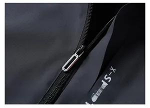 Detailed macro view of high-quality metal zipper with red accents on windproof jacket