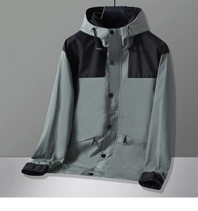 Detail of outdoor hooded jacket featuring color-block windproof fabric and adjustable cuffs