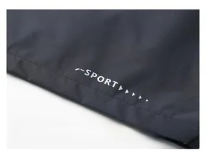 Detail macro view of the X-SPORT back print design on dark grey windbreaker fabric