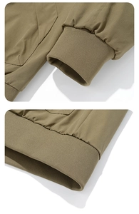 Detailed macro view of khaki ribbed elastic cuffs and hem on a men's baseball jacket