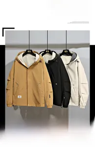 Dettaglio delle giacche a vento con cappuccio nei colori senape, nero e beige