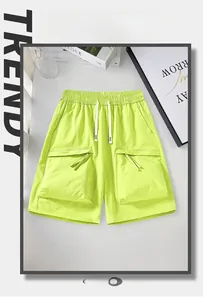 Detail of neon green cargo shorts with elastic waist, drawstrings and 3D utility pockets