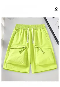 Detail of neon green cargo shorts featuring elastic drawstring waist and large utility pockets