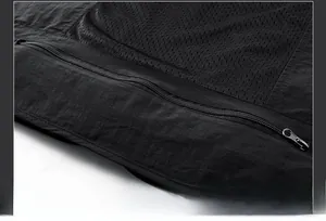 Close-up of the breathable mesh back and rear zipper pocket on a black fishing vest