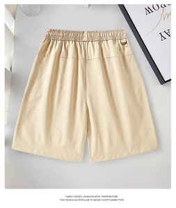 Detail of light beige cargo shorts with elastic waistband and black D-ring buckle