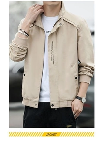 Detail of beige men's jacket showing snap buttons and text print on the stand collar
