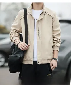 Detailed view of khaki jacket with vertical text print and ribbed cuffs on street background